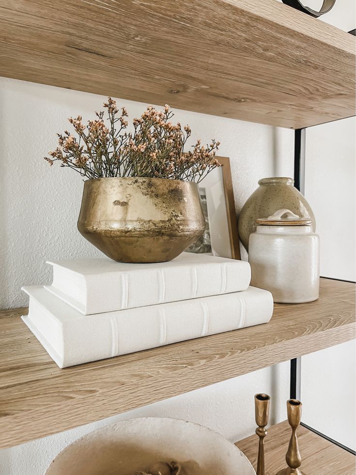 books and vases are sitting on the shelves