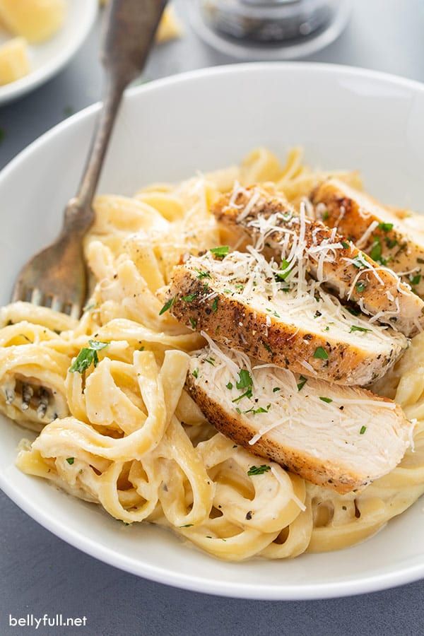 a white bowl filled with chicken and pasta