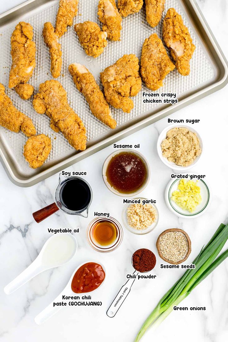 the ingredients to make chicken wings on a baking sheet, including sauces and seasonings