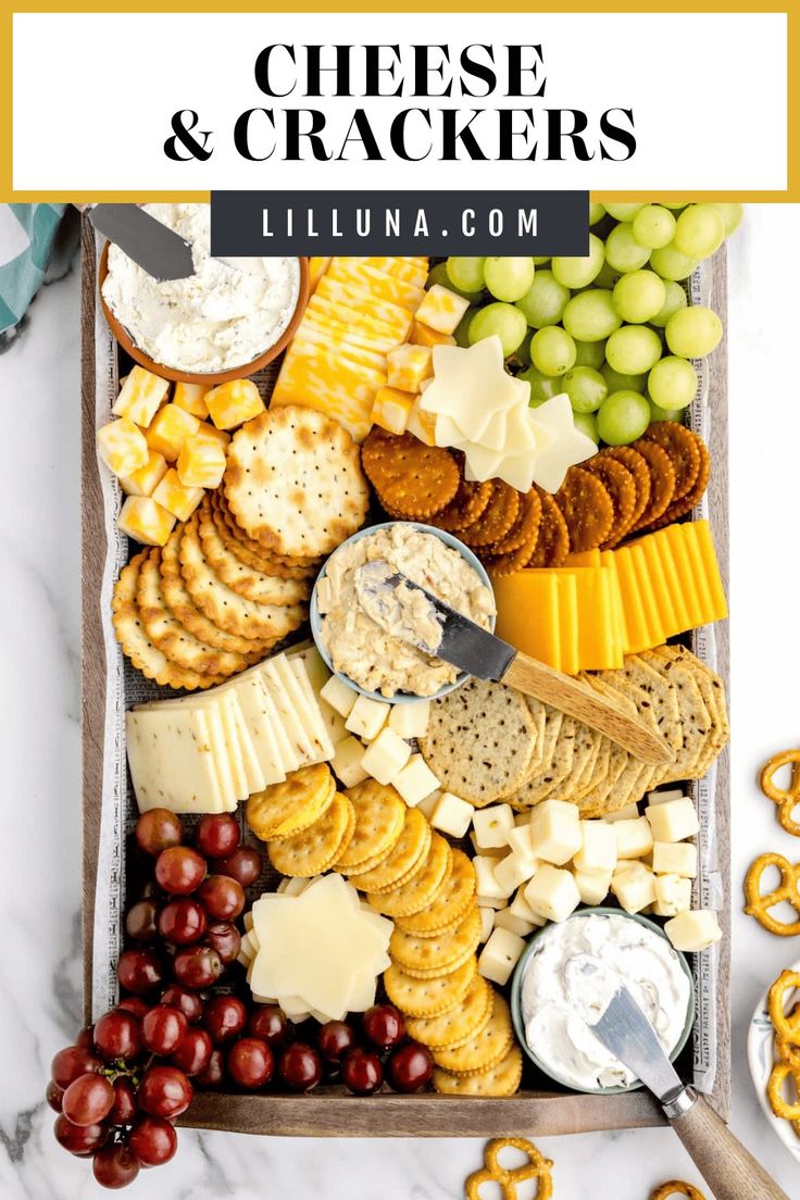 the cheese and crackers platter with grapes, pretzels, crackers, olives