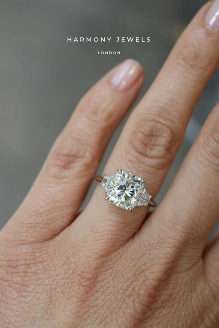 a woman's hand with a diamond ring on it and the words harmony jewels