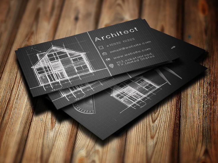 three black and white business cards sitting on top of a wooden table