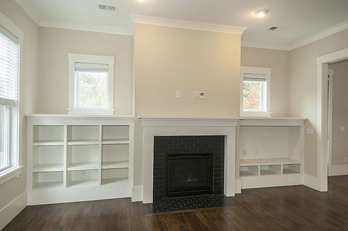 empty living room with fireplace and built in bookshelves