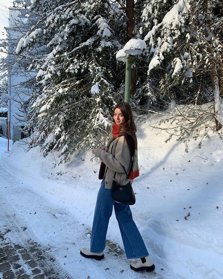 a woman walking down a snow covered road