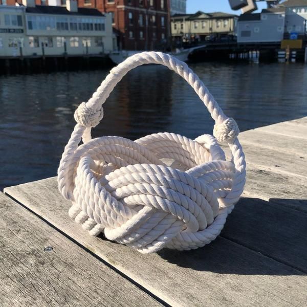 a white rope on the end of a wooden dock next to some buildings and water