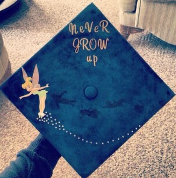 a blue graduation cap with the words never grow up on it and a tinkerbell fairy