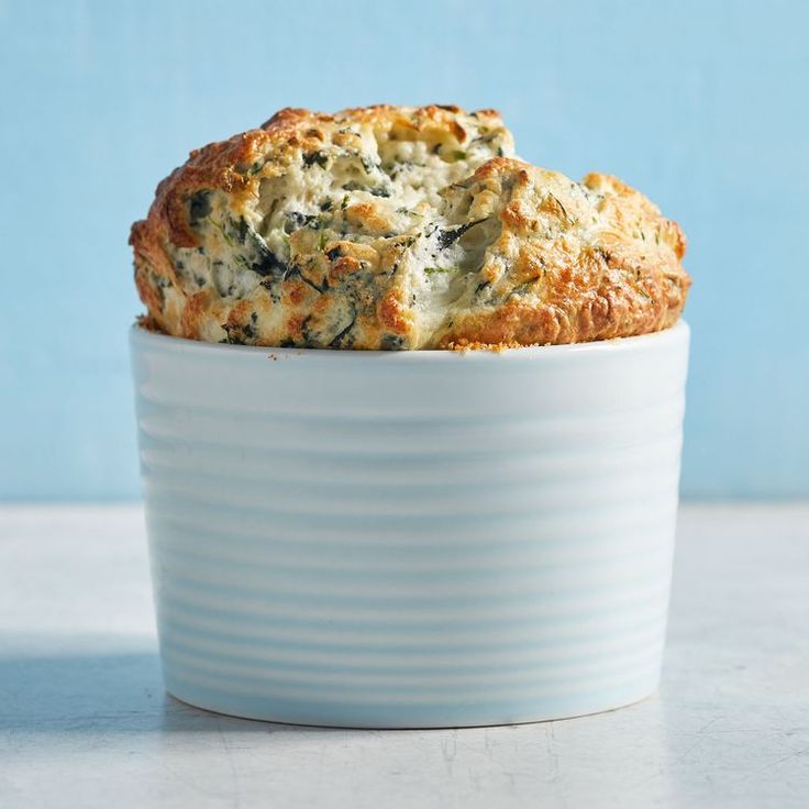 a close up of a muffin in a bowl on a table with a blue background