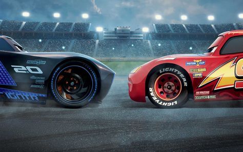 two cars racing on a track in front of an empty stadium with lights at night