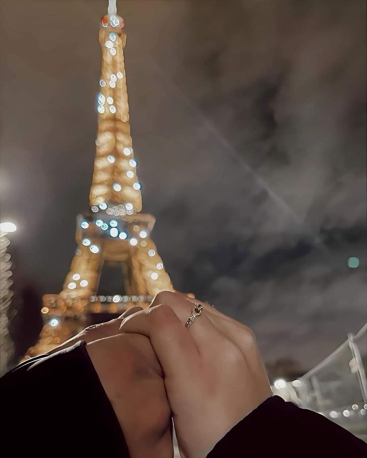 the eiffel tower is lit up at night