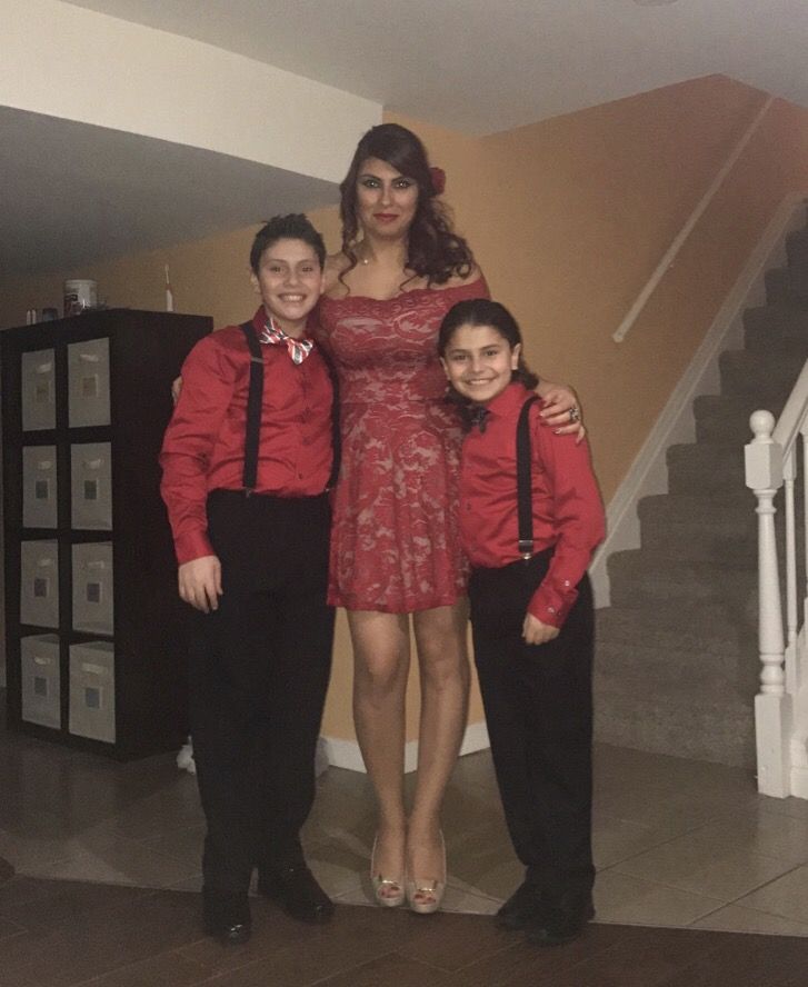 three people in red shirts and black pants standing next to each other on the stairs