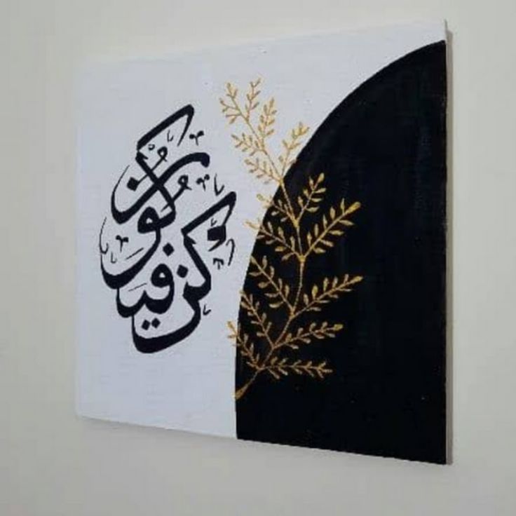 an arabic calligraphy is displayed on the wall above a painting in gold and black