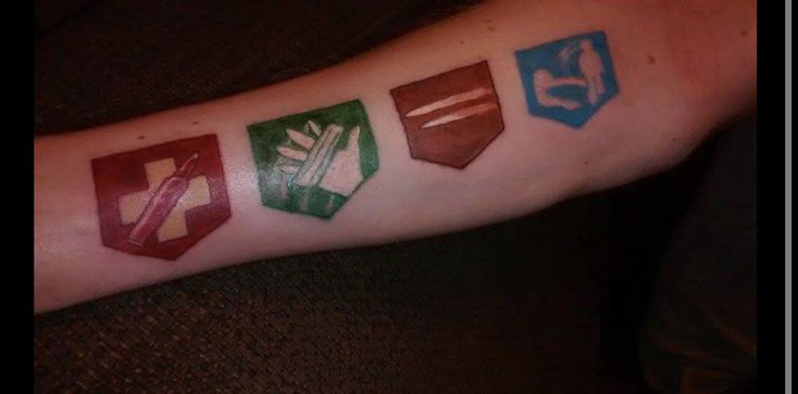 a person with a tattoo on their arm that has four different symbols painted on it