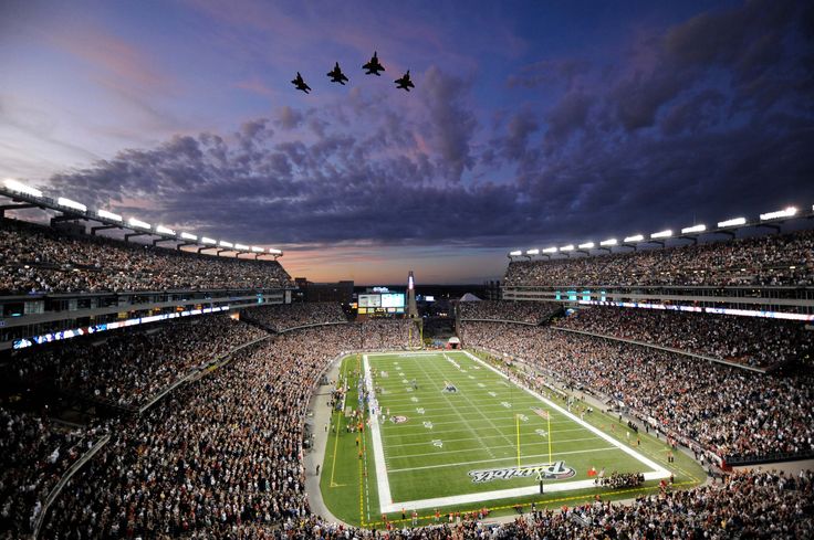 two jets fly over a football stadium as the sun sets