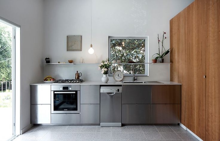 a modern kitchen with stainless steel appliances and wood cabinetry is seen in this image