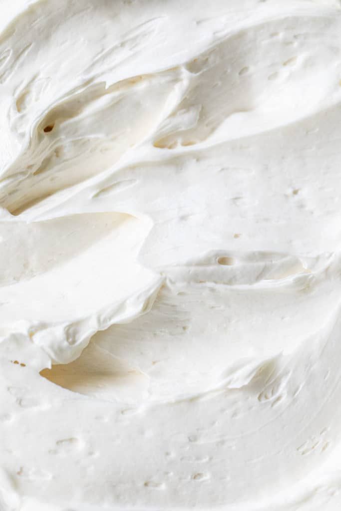 a close up view of a cake with white frosting on it's icing