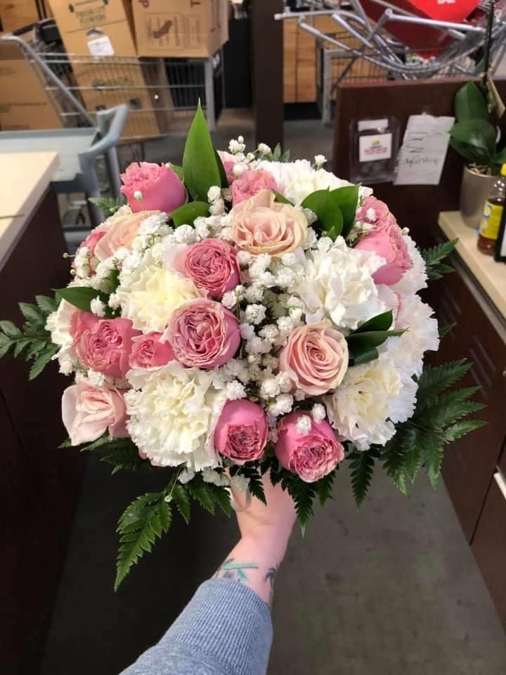 someone holding a bouquet of pink and white flowers