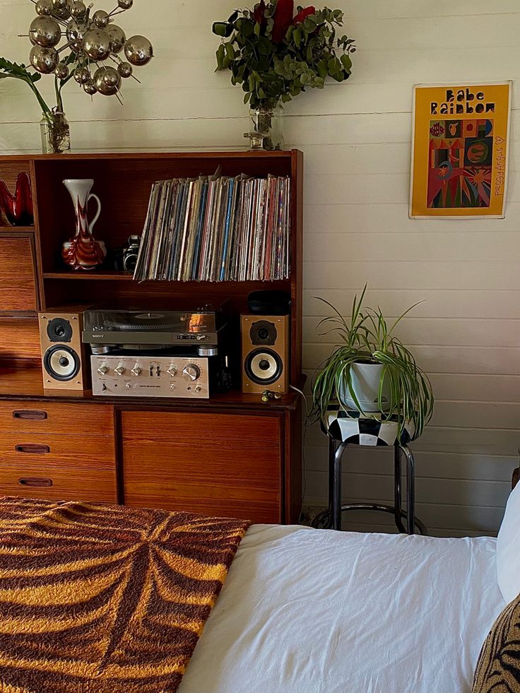 a bed room with a neatly made bed and a book shelf on the wall next to it