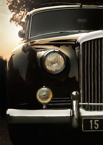 the front end of an old black car