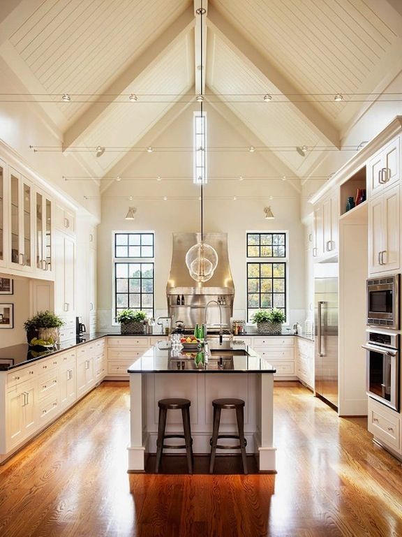 a large kitchen with an island and two stools in it's center area