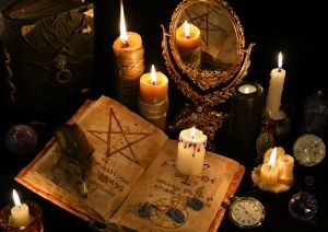 an open book surrounded by candles and other items