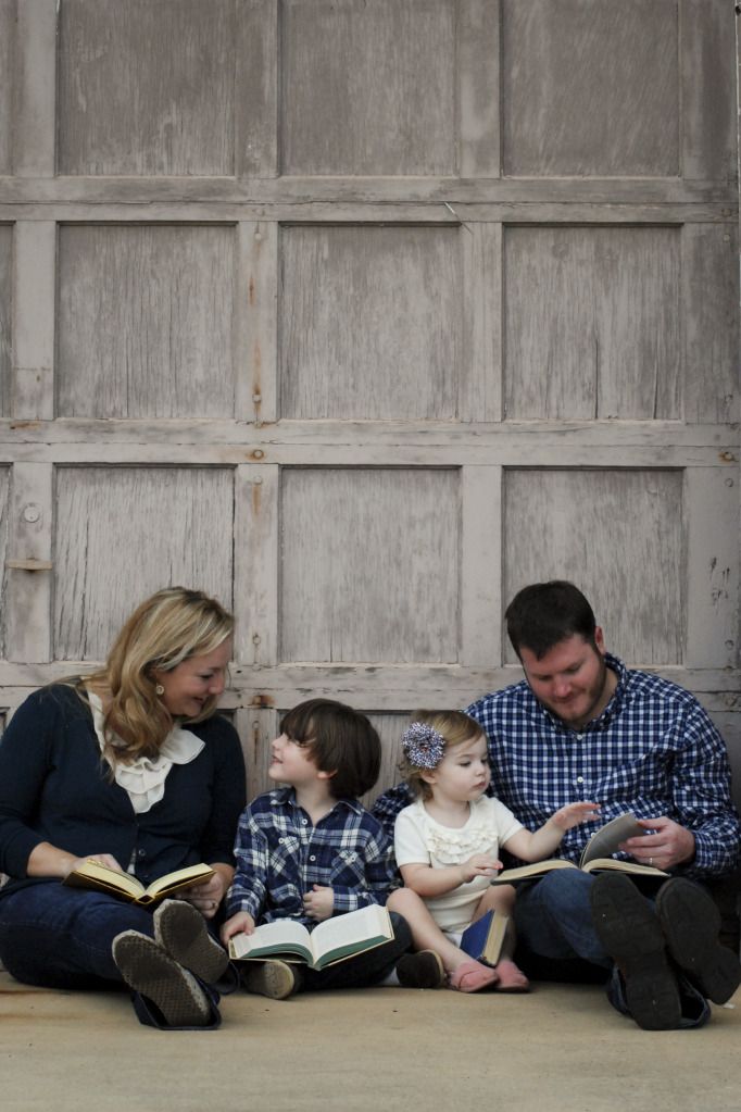 a family sitting on the ground reading books