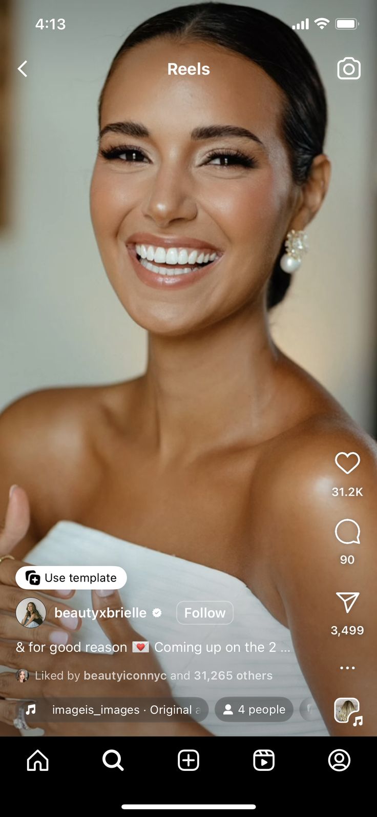 a woman in a white dress smiling and holding her hand up to the camera,