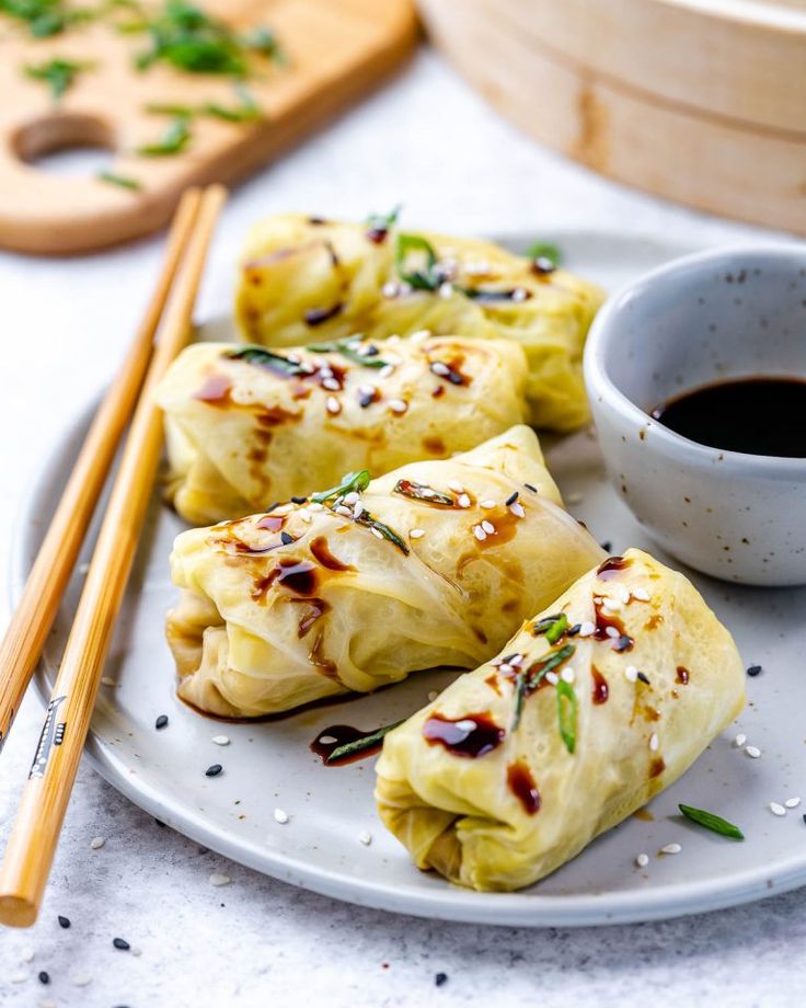 some food is sitting on a plate with chopsticks next to it and a cup of coffee