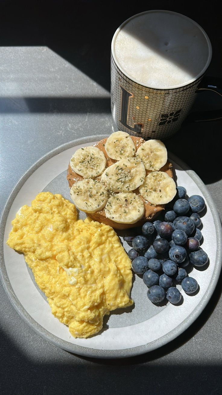 an omelet, toast, and blueberries are on a plate next to a cup of coffee