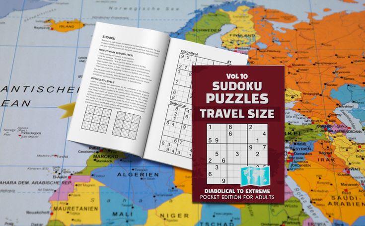 the sudoku puzzles travel size book is open on a world map and it's contents are laid out