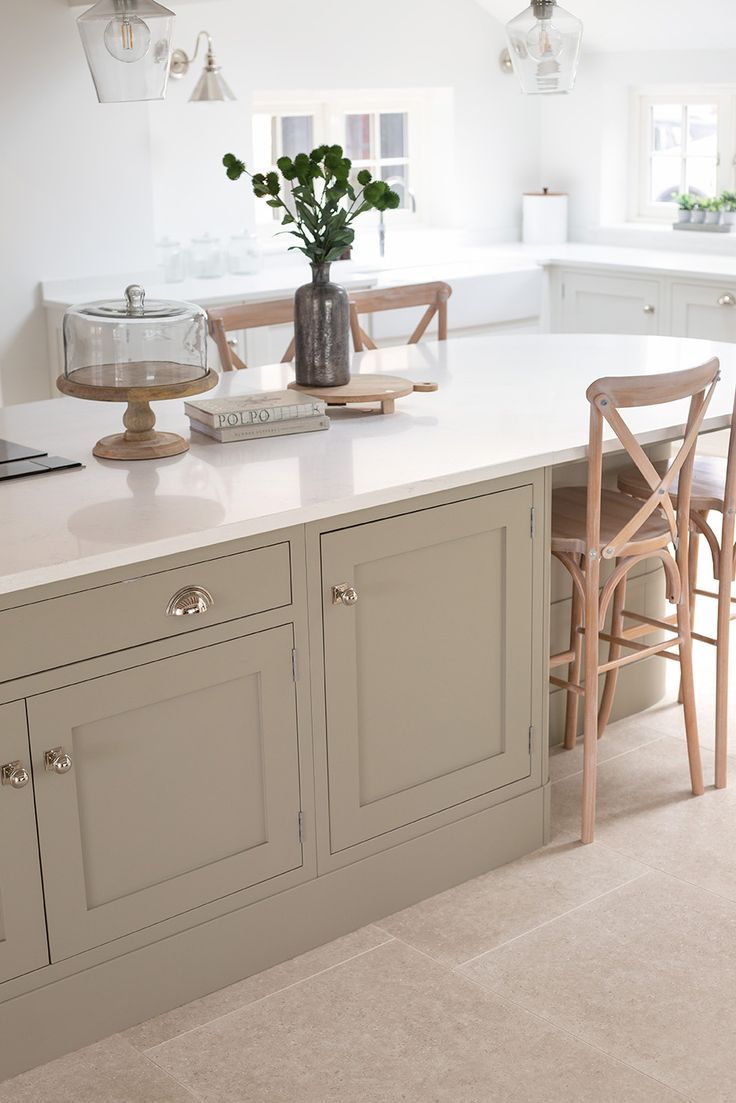 a kitchen island with two chairs and a potted plant on it