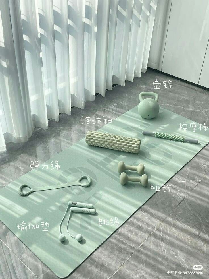 an exercise mat with dumbs, kettles and other items on it in front of curtains