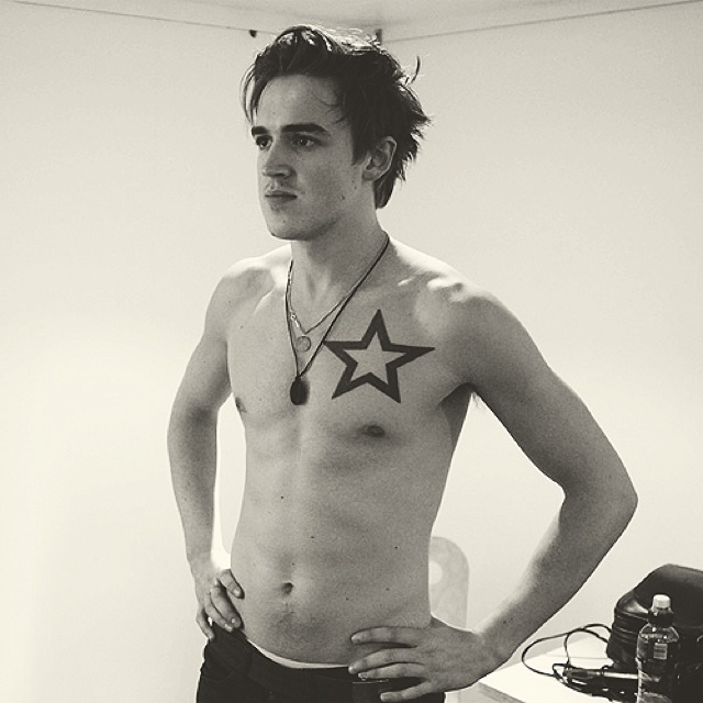 a shirtless man with a star tattoo on his chest