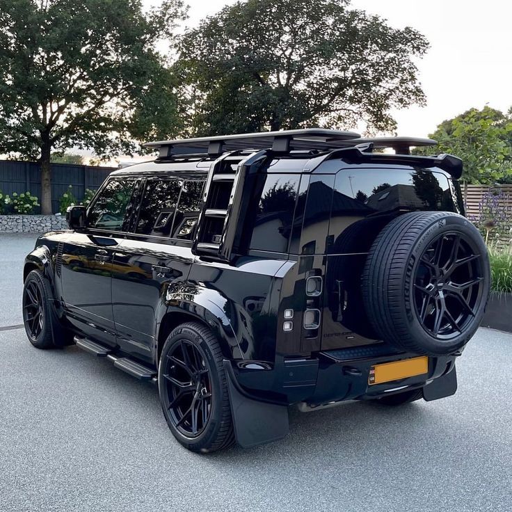 the rear end of a black suv parked in a parking lot