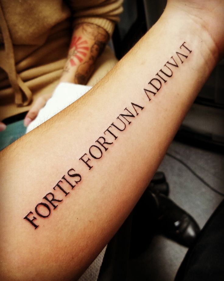 a person with a tattoo on their arm that says fortis fortuna adulti