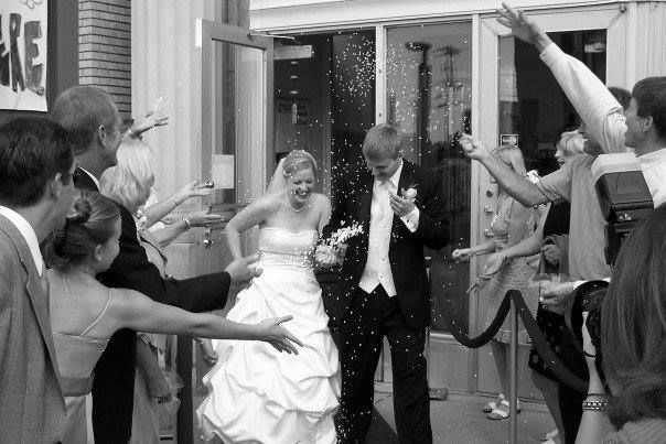 a bride and groom are showered with confetti as they walk down the street