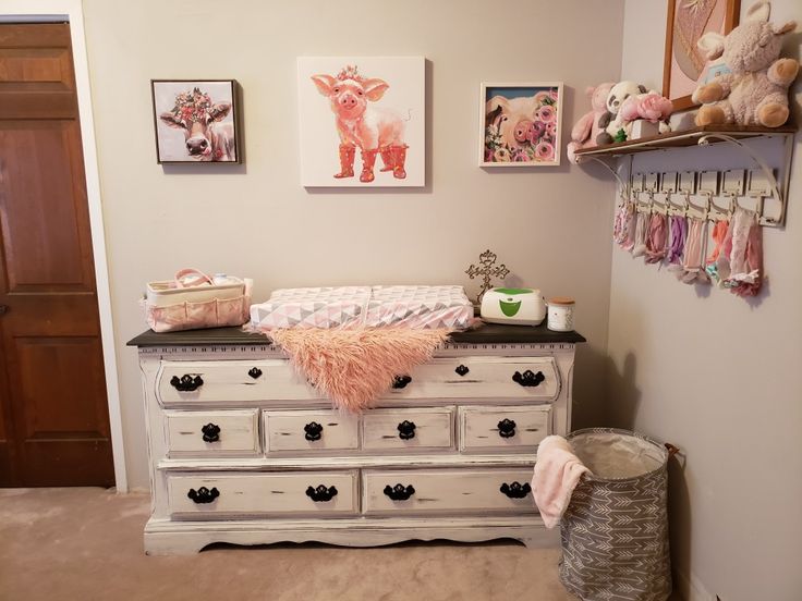 a baby's room with an old dresser and pictures on the wall