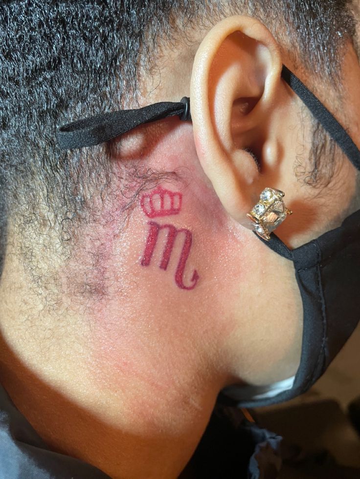 a close up of a person with a tattoo on their ear and behind the ear