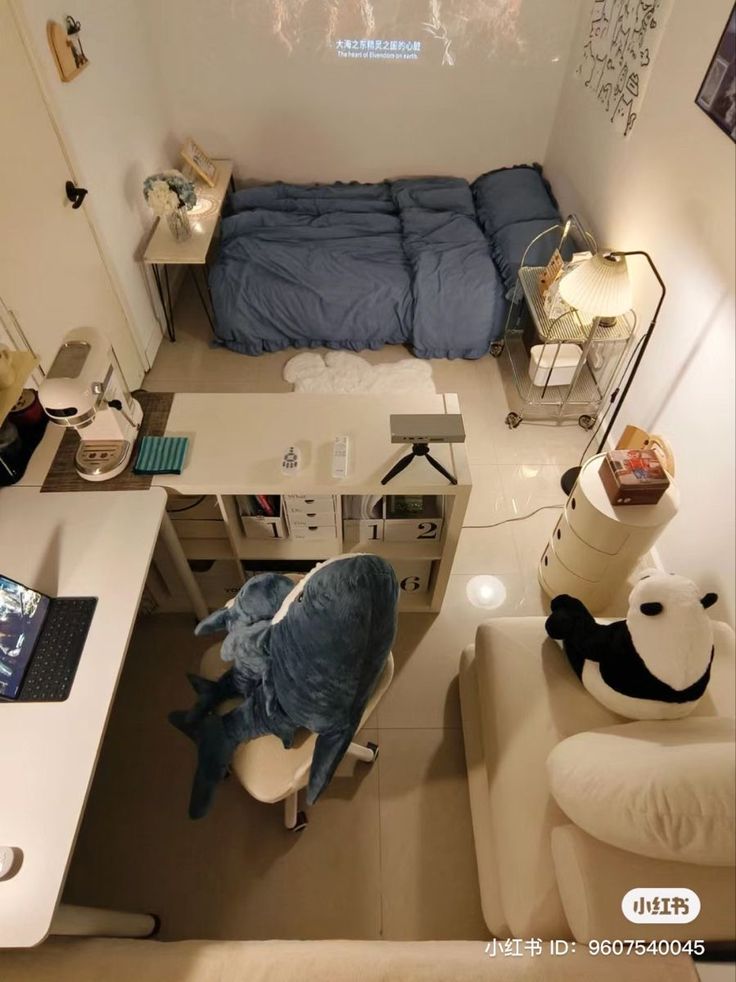 an aerial view of a bedroom with a bed, desk and laptop on the floor