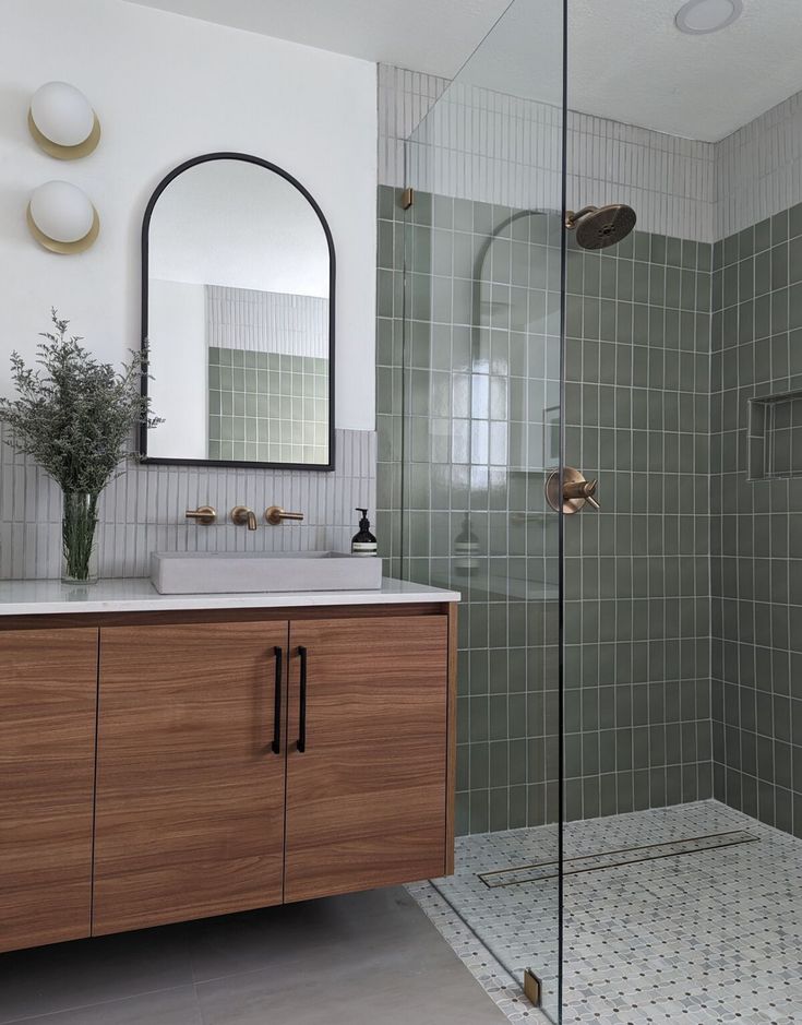 a bathroom with a sink, mirror and shower stall