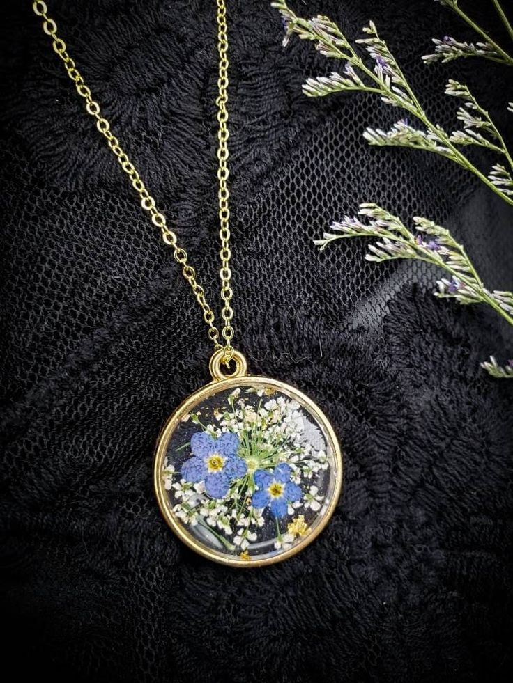 These beautiful flowers are frozen and time and will never lose their bloom or fade! Each Forget Me Not necklace will contain two Forget-Me-Not Flowers, and one Queen Anne's Lace wildflower, along with dazzling, pretty gold leaf flakes which sparkle in the sunlight. This necklace is a beautiful piece of pressed flower jewelry and they will look stunning on whoever wears these unique jewelry gifts. This pretty Flower Necklace is made with REAL dried and pressed flowers! The Forget-Me-Not and Quee Resin Pressed Flower Necklace, Forget Me Not Flower Necklace, Forget Me Not Jewelry, Wildflower Jewelry, Cottagecore Car, Loop Earplugs, Resin Flower Necklace, Dried Flower Necklace, Handmade Gold Necklace