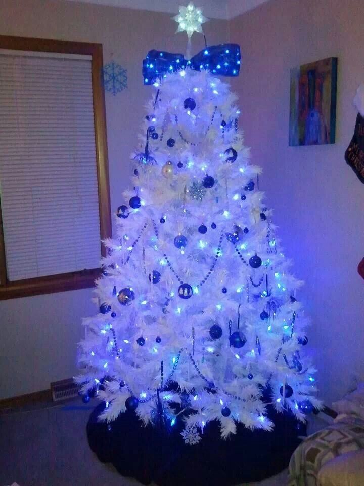 a white christmas tree decorated with blue and silver ornaments