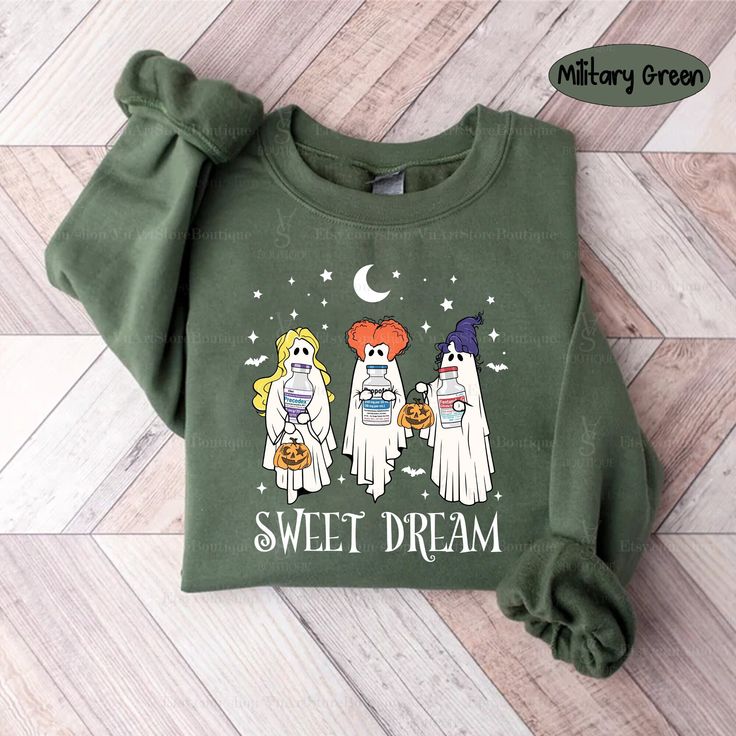 a green sweatshirt with three ghostes on it and the words sweet dream written in white