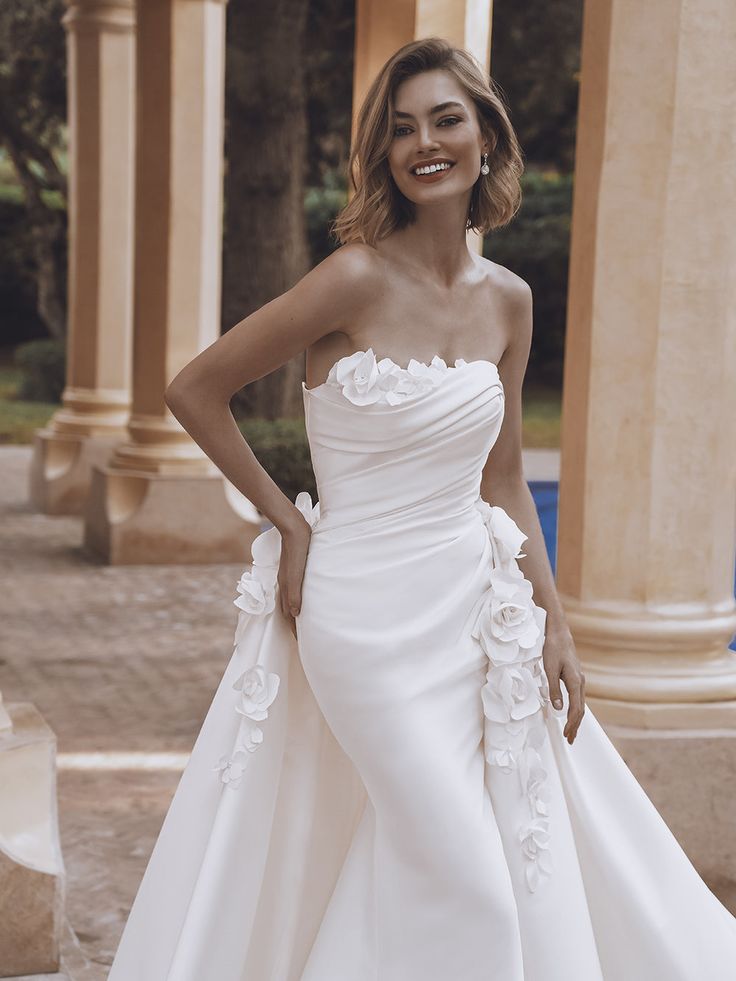 a woman in a wedding dress posing for the camera