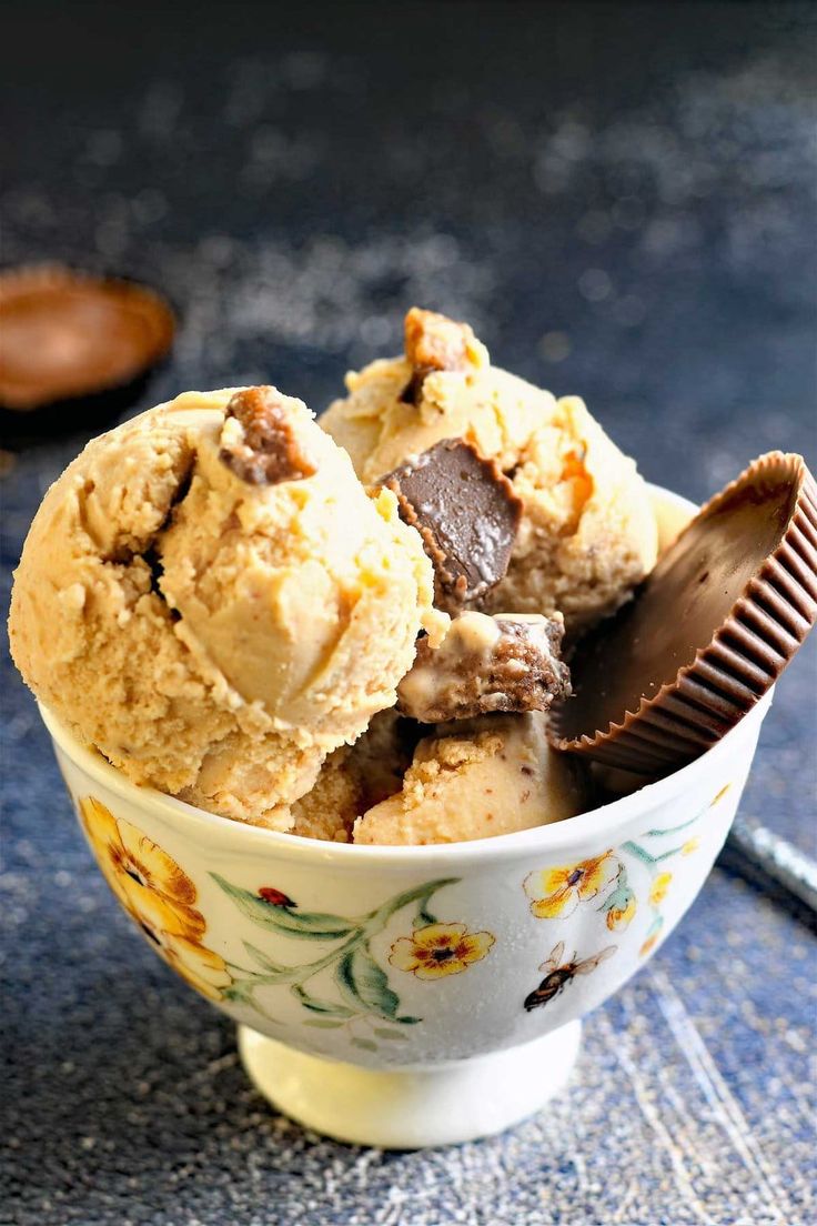 two scoops of ice cream in a floral bowl with a chocolate bar on top