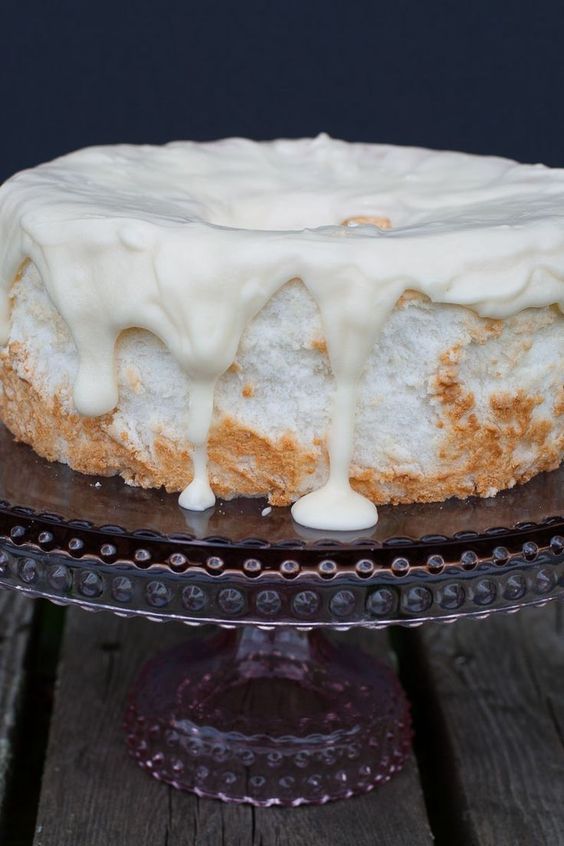 a cake sitting on top of a glass plate covered in icing