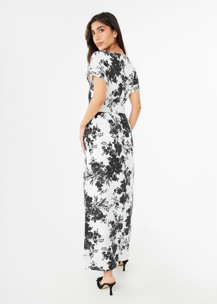 The Heidi Gown is inspired by retro caftan dresses reminiscent of 1960s glamour. This effortless style features a slashed v-neckline and a removable self-tie belt so you can accentuate the waistline, or wear the dress as a roomy gown. The romantic floral print is a vision of Summer elegance when paired with a heel and evening bag! Generous fit: We recommend sizing down if you are in between sizes. Make: Short Sleeve, V-Neckline, Back zipper closure, Fully lined, Removable self-tie belt Measureme Evening V-neck Maxi Dress With Tie Waist, V-neck Maxi Dress With Tie Waist For Evening, Evening V-neck Belted Maxi Dress, Belted V-neck Maxi Dress For Evening, Evening V-neck Dress With Tie Waist, Evening Belted Maxi Dress With Surplice Neckline, White V-neck Maxi Dress With Tie Waist, Formal Short Sleeve Maxi Dress With Tie Waist, Chic Floor-length Tie Waist Dress