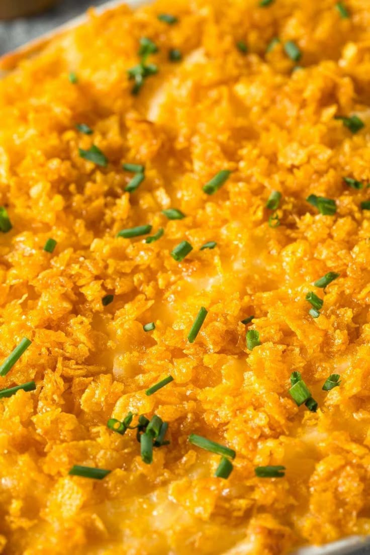 a casserole dish with cheese and chives on top, ready to be eaten