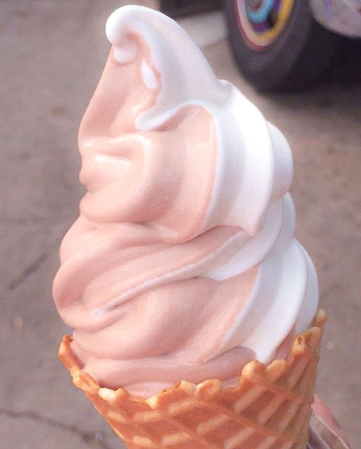 an ice cream cone with pink icing on top