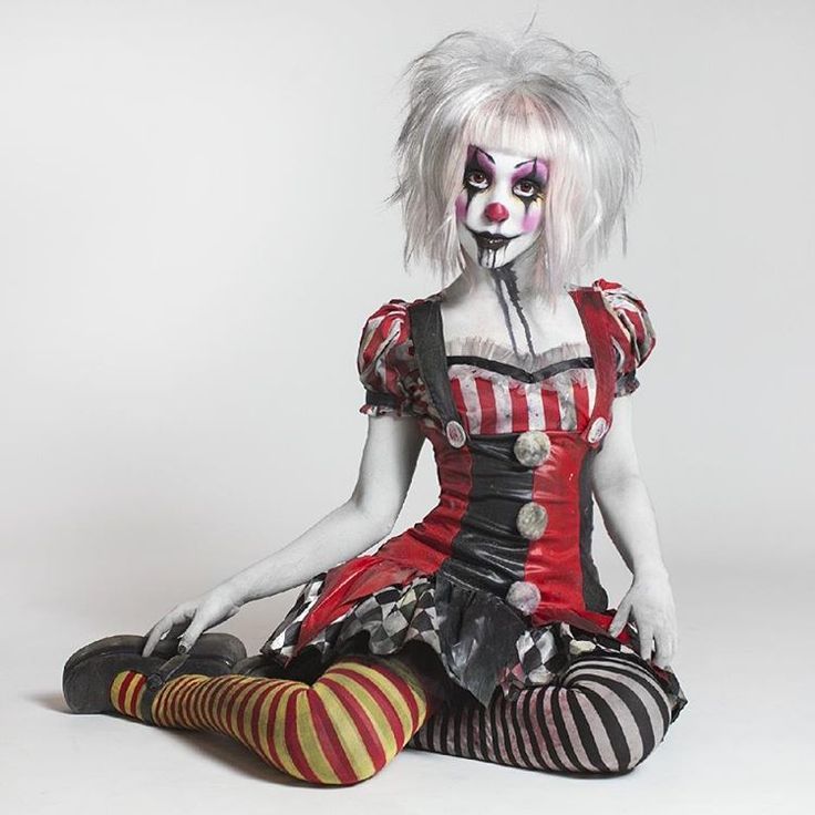 a woman dressed as a clown sitting on the floor