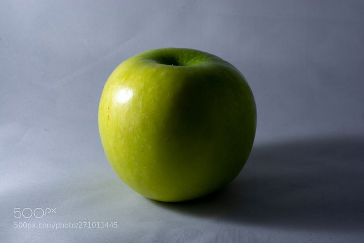 an apple sitting on top of a white table